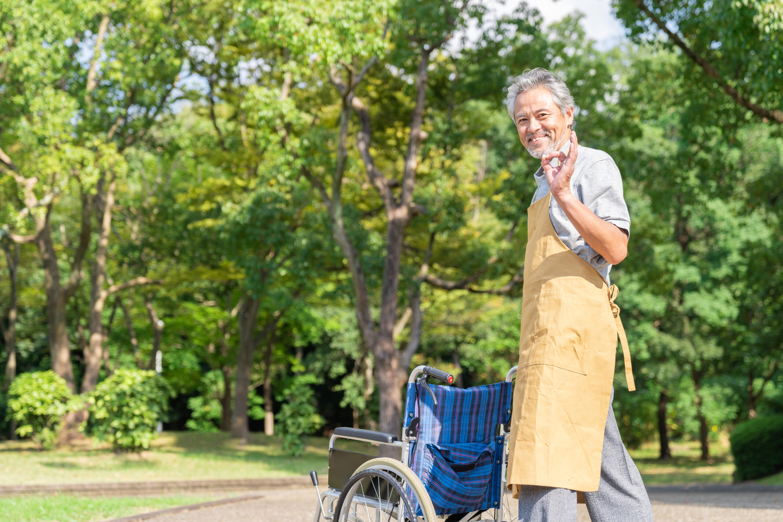 車椅子を押すシニア介護士